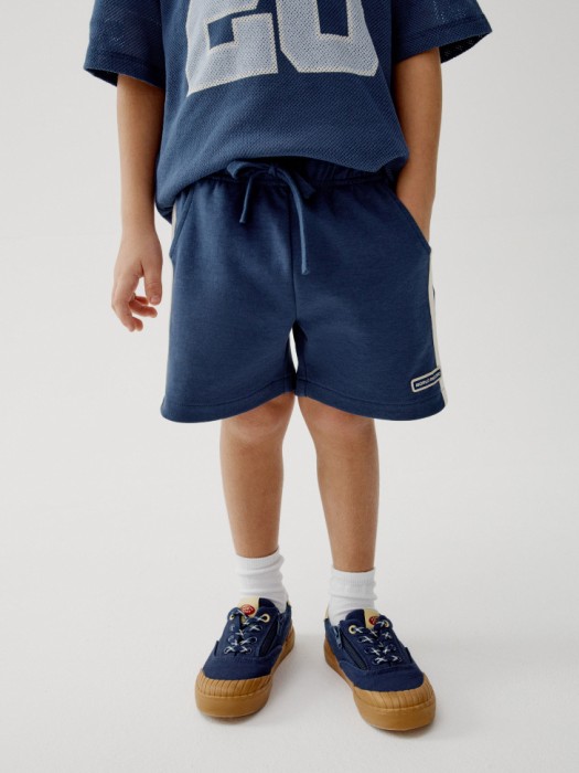трикотажные шорты с лампасами для мальчиков от бренда sela вид слева