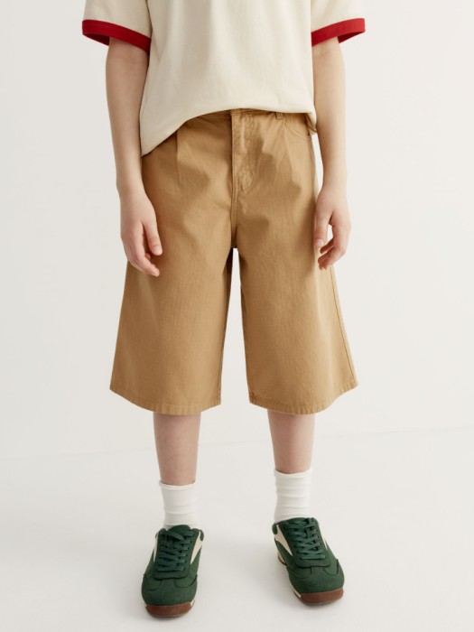 удлиненные шорты из фактурного хлопка для мальчиков от бренда sela вид слева