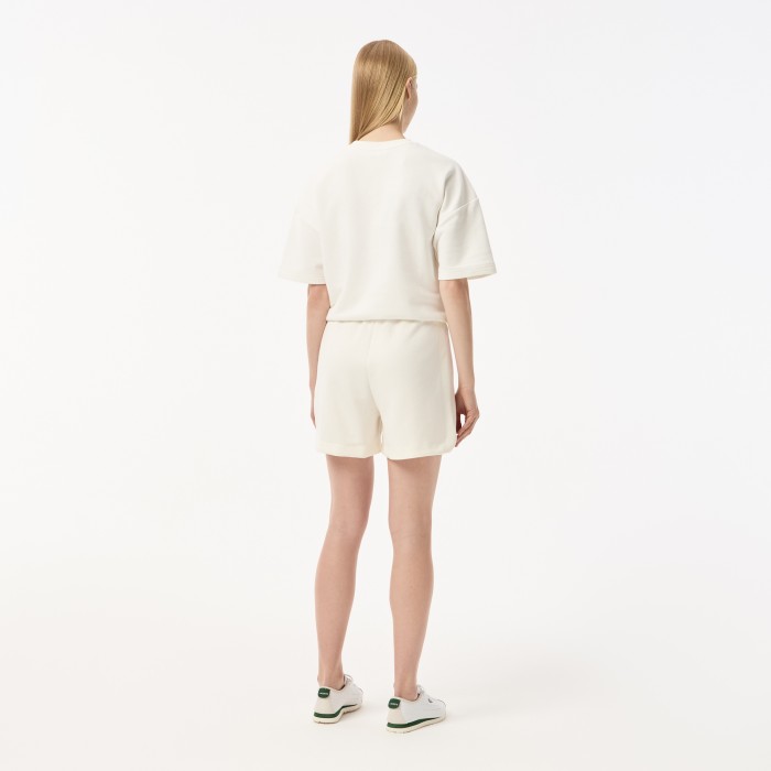 женские спортивные шорты  с карманами от бренда lacoste вид слева